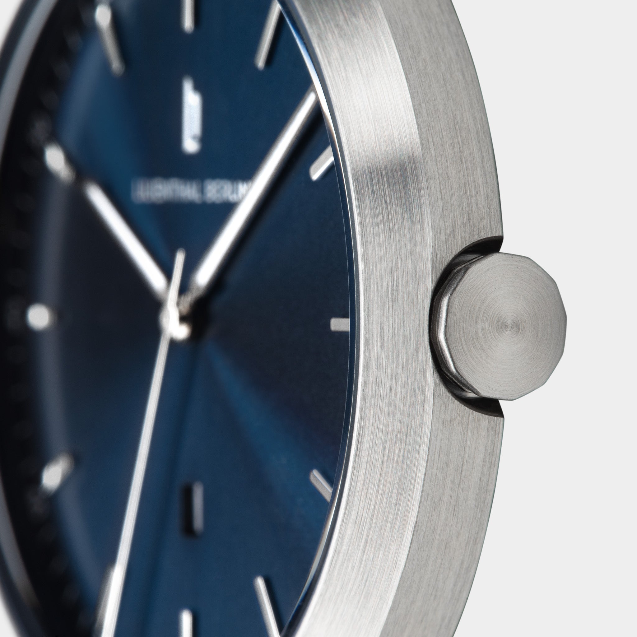 Close-up of minimalist silver watch with blue dial and silver hour markers