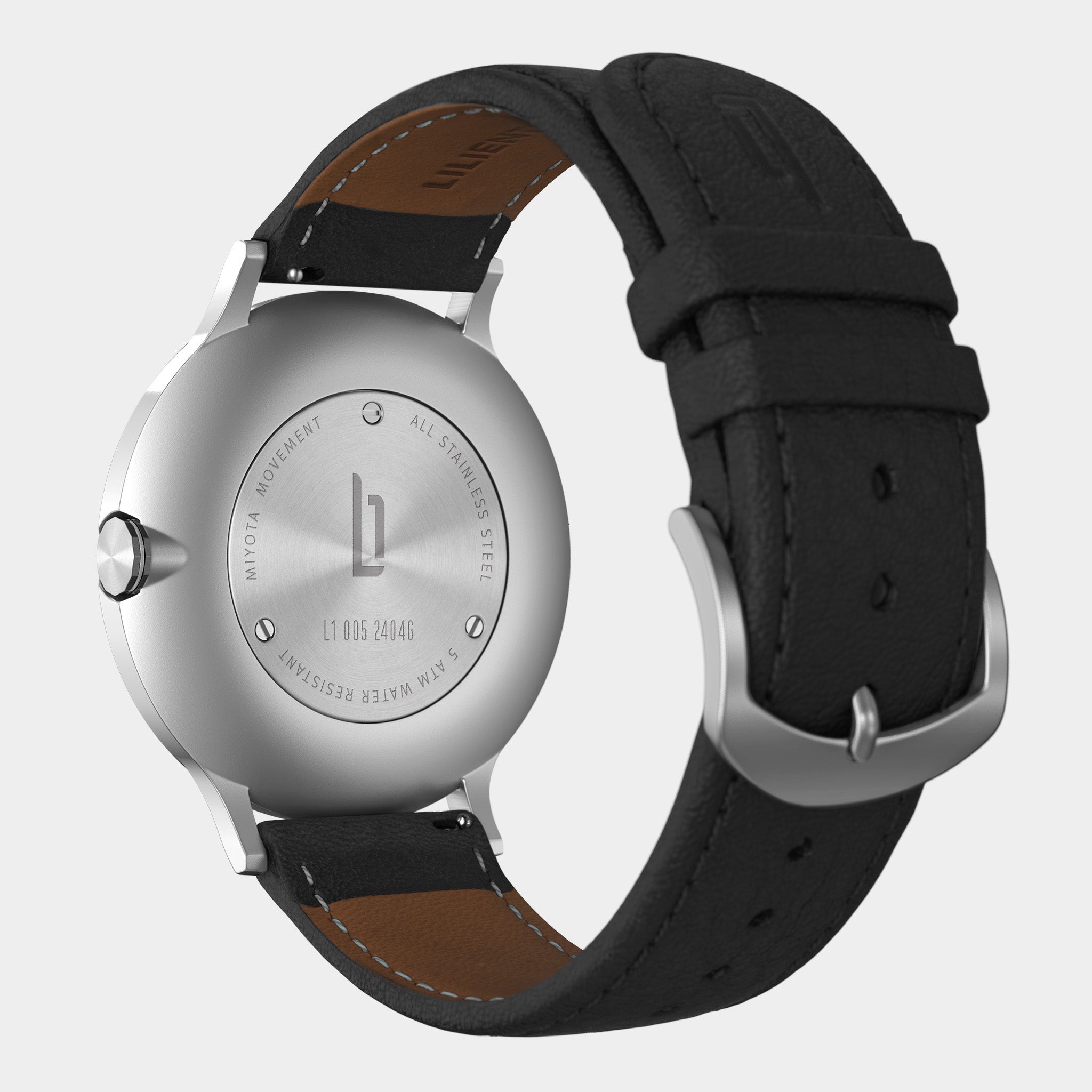 Stainless steel watch case back with black leather strap, visible detailed engravings