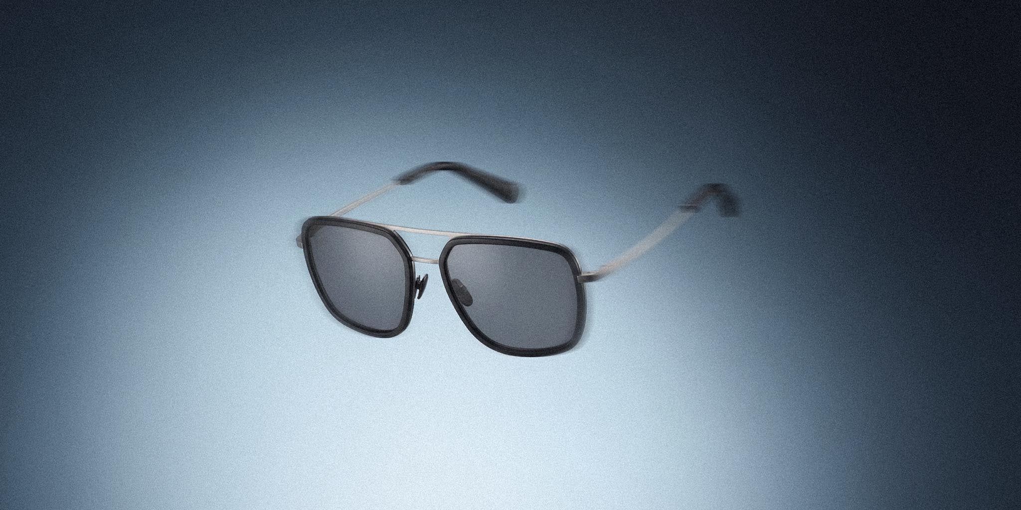 Modern rectangular sunglasses with dark lenses and thin metal frame on gradient background