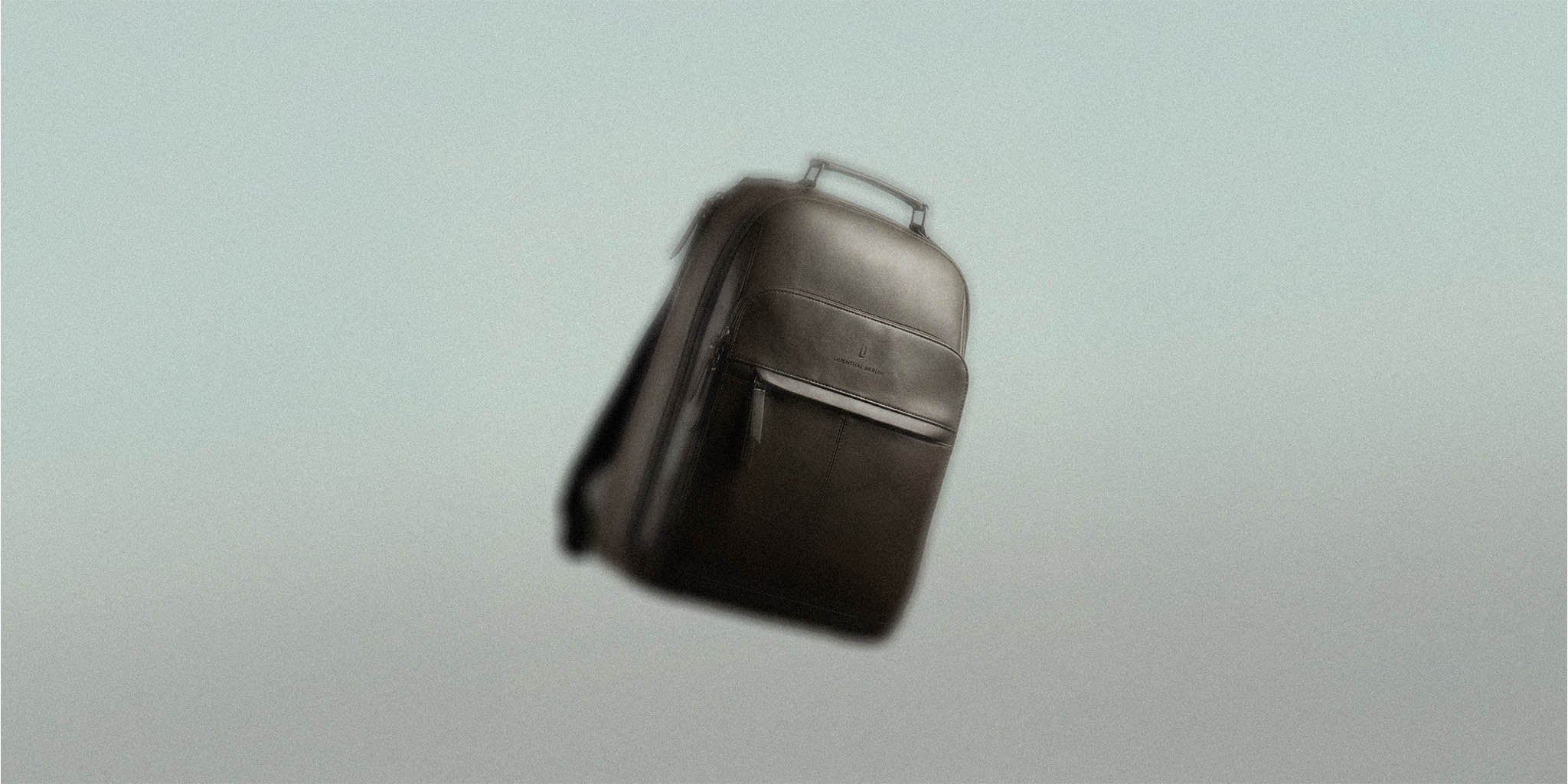 Sleek black backpack with top handle and front pocket, floating against a neutral background.