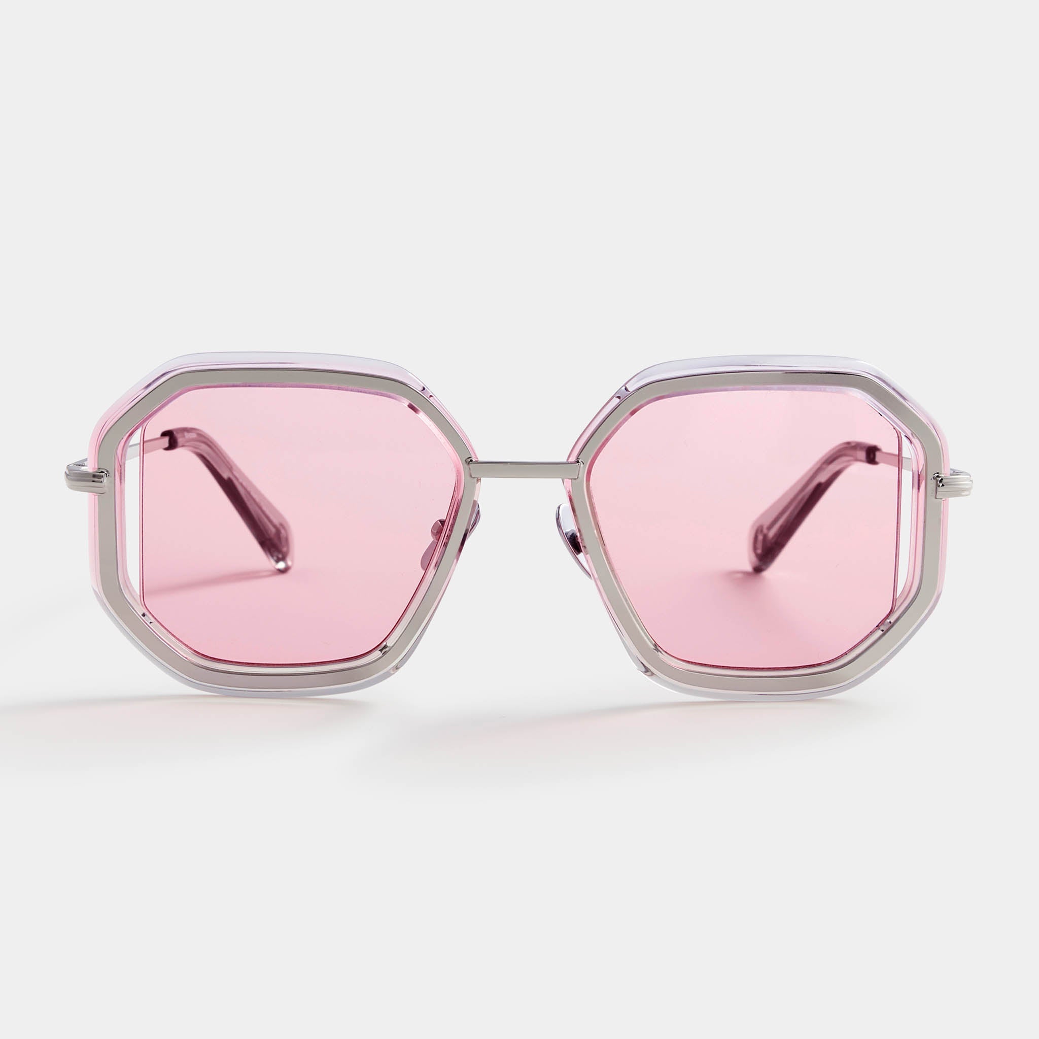 Geometric sunglasses with silver frame and pink lenses on white background