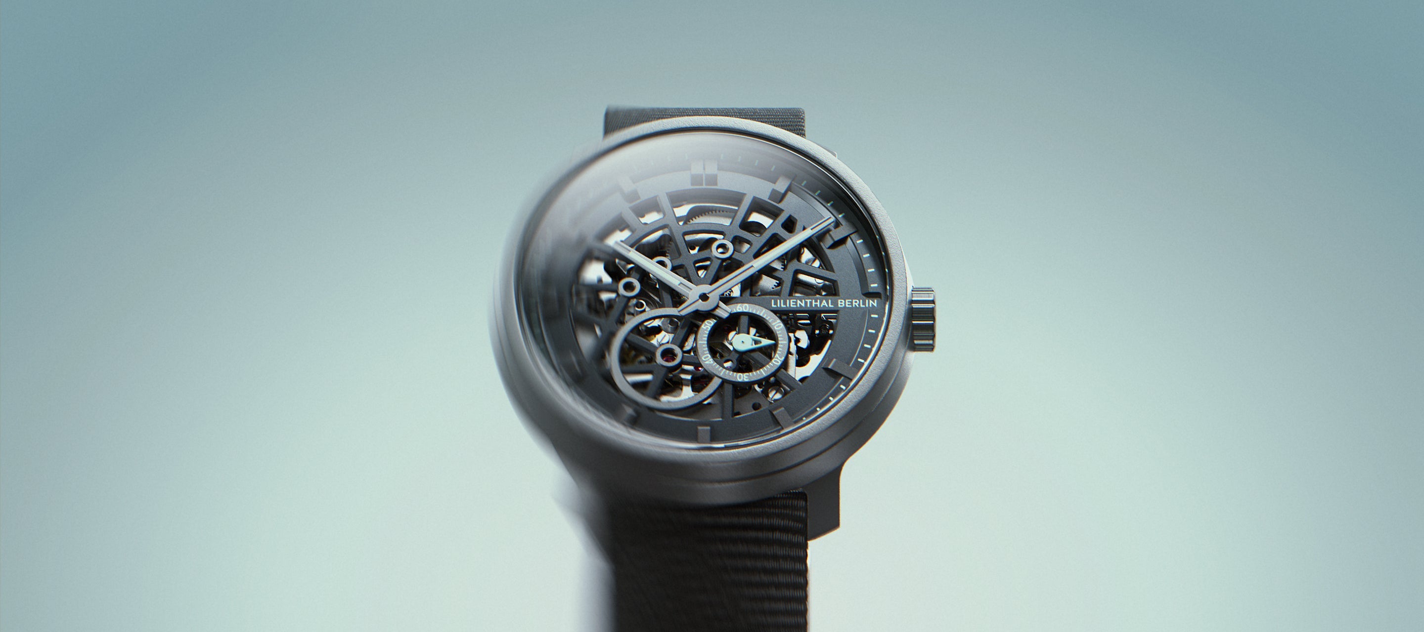 Skeleton dial mechanical watch with visible gears and mesh strap on light background