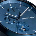Close-up of a blue chronograph watch face with subdials and date display