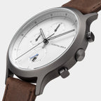 Minimalist chronograph watch with white dial, brown leather strap, and stainless steel case