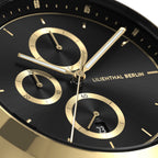 Close-up of luxury black and gold chronograph watch face with three subdials and date display