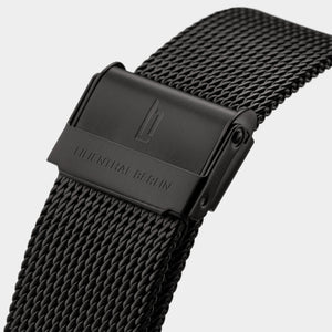 Close-up of black stainless steel mesh watch strap with embossed clasp and logo