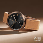 Elegant men's watch with black dial, rose gold case, tan leather strap, German Design Award 2021.