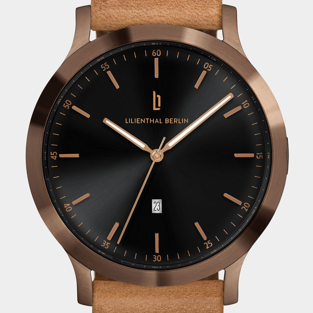 Elegant wristwatch with black dial, bronze case, gold hour markers, and tan leather strap