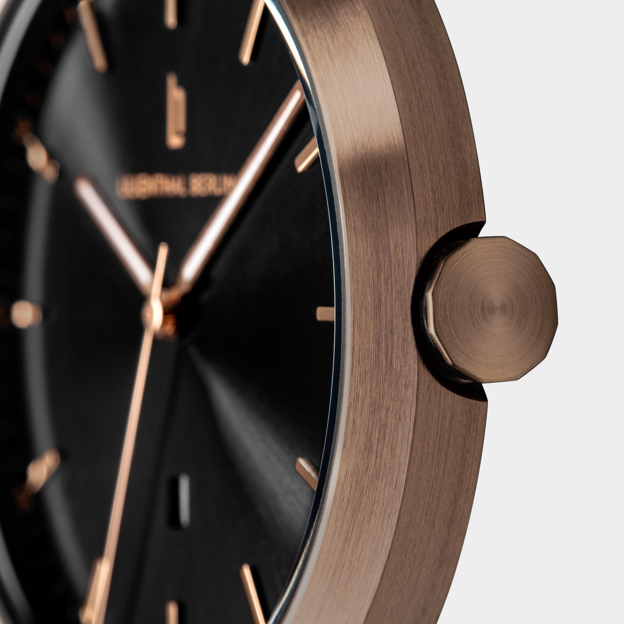 Close-up of a modern wristwatch with a black dial and rose gold case and details
