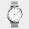 Minimalist silver mesh watch with white dial and black numerals on a light background