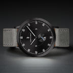 Minimalist black watch with grey leather strap, modern dial, and distinctive white markers