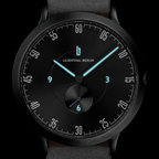 Black minimalist wristwatch with luminous blue hands and a sleek dial, close-up