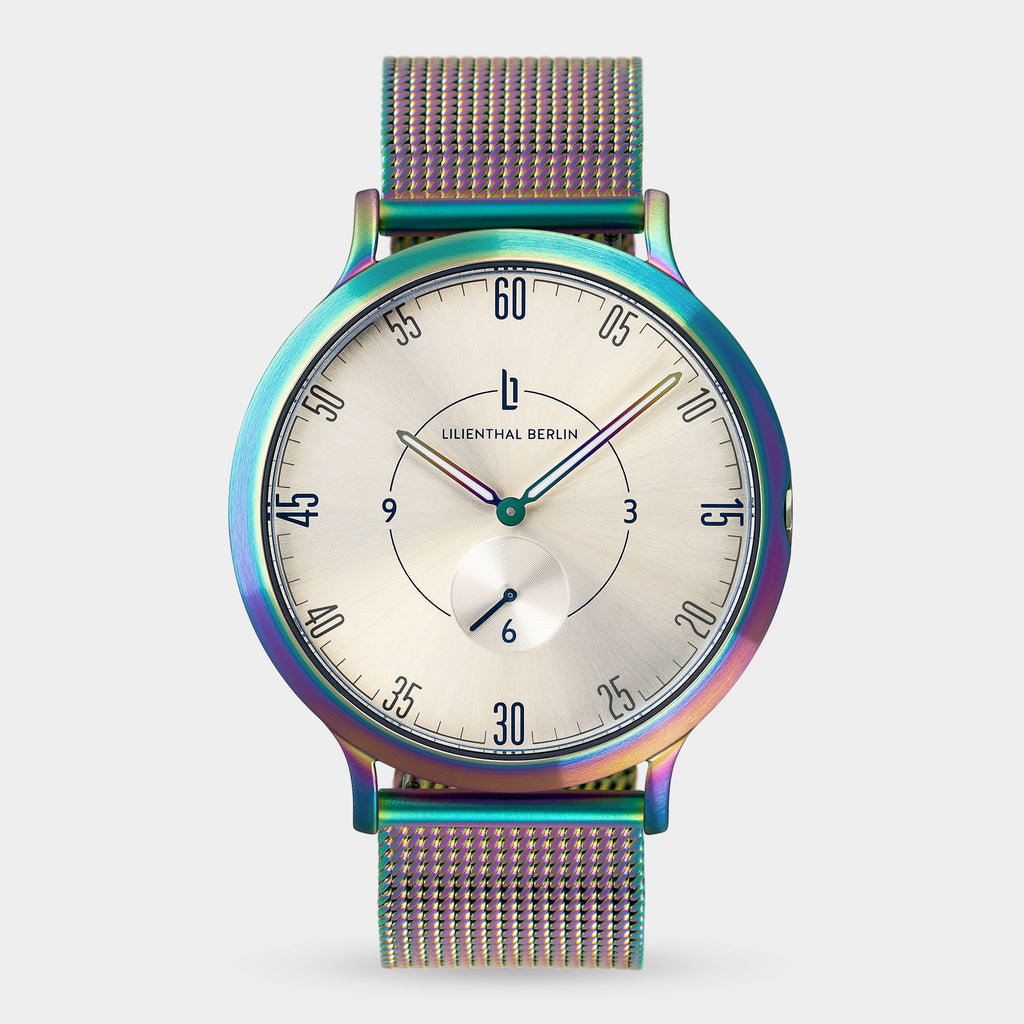 Minimalist iridescent mesh strap watch with silver sunray dial and small seconds subdial