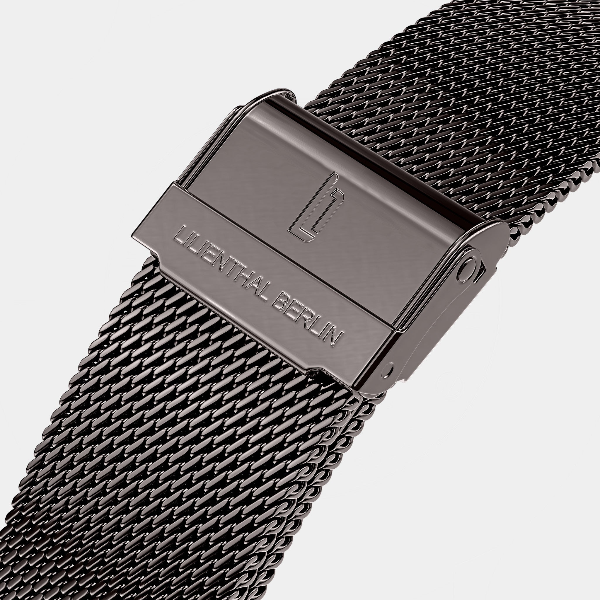 Close-up of a stainless steel mesh watch strap with engraved clasp on white background